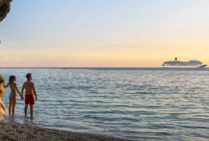 una coppia in spiaggia e sullo sfondo una crociera